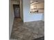 Hallway with neutral tile flooring leading to kitchen with breakfast bar at 5035 N 10Th Pl # 109, Phoenix, AZ 85014