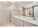 Bright bathroom features a double sink vanity, large mirror, and neutral tiling at 509 N Hobson Plz, Mesa, AZ 85203