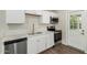 Well-lit kitchen features stainless steel appliances, white cabinets, and hardwood flooring at 556 S Forest --, Mesa, AZ 85204