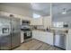 Modern kitchen featuring stainless steel appliances, granite countertops, white cabinets, and hardwood flooring at 7930 W Colter St, Glendale, AZ 85303
