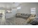 Open-concept living room featuring high ceilings, hardwood flooring, and a comfortable gray sofa at 7930 W Colter St, Glendale, AZ 85303