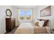 Comfortable bedroom with a large window, stylish decor, wood-look floors, and ample natural light provides inviting space at 8012 W Griswold Rd, Peoria, AZ 85345