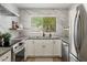 Bright kitchen features white cabinets, modern stainless steel appliances, and stylish countertops with marble backsplash at 810 E Potter Dr, Phoenix, AZ 85024