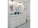Bright bathroom with dual sinks, stylish lighting, oval mirrors, toilet, white cabinets, and a marble countertop at 8102 E Cambridge Ave, Scottsdale, AZ 85257