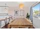 Bright dining area with a wooden table, stylish chairs, and a modern chandelier, open to the kitchen with bar seating at 8102 E Cambridge Ave, Scottsdale, AZ 85257
