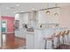 Modern kitchen with stainless steel appliances, white cabinets, marble countertops, and a breakfast bar with seating for three at 8102 E Cambridge Ave, Scottsdale, AZ 85257
