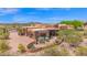Expansive desert home with a terracotta facade, landscaped front yard, and mountain views at 8154 E Tecolote Cir, Scottsdale, AZ 85266