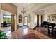 Elegant foyer featuring tiled floors, a chandelier, and an arched entrance leading to a piano room at 8154 E Tecolote Cir, Scottsdale, AZ 85266
