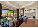Expansive living room with fireplace, terracotta tile flooring, and large windows overlooking the patio at 8154 E Tecolote Cir, Scottsdale, AZ 85266