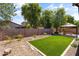 Cozy backyard featuring a gazebo, desert rock landscaping, and artificial turf at 838 W Basswood Ave, Queen Creek, AZ 85140