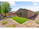Manicured backyard with artificial turf, desert rock landscaping, and a gazebo at 838 W Basswood Ave, Queen Creek, AZ 85140