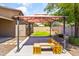 Backyard area with gazebo and built in benches, surrounded by green trees and desert landscaping at 838 W Basswood Ave, Queen Creek, AZ 85140