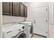 The laundry room includes a washer, dryer, and overhead cabinet storage at 838 W Basswood Ave, Queen Creek, AZ 85140