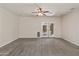 Spacious living room with neutral carpeting, a ceiling fan, and a double door to the outside at 838 W Basswood Ave, Queen Creek, AZ 85140
