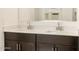 Bathroom featuring dual sinks with quartz countertop and dark wood cabinetry at 8634 W Albeniz Pl, Tolleson, AZ 85353