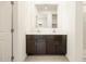 Modern bathroom boasts double sinks, dark wood cabinets, and a large mirror at 8634 W Albeniz Pl, Tolleson, AZ 85353