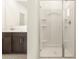 Bright bathroom with a glass-enclosed shower, neutral tile, and built-in shelving at 8634 W Albeniz Pl, Tolleson, AZ 85353