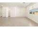Bright living area boasts large windows, neutral tiling, and white walls that offer a calming, flexible living space at 8634 W Albeniz Pl, Tolleson, AZ 85353