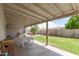 Inviting covered patio featuring a dining area and view of a well-maintained backyard with mature trees at 903 W Shawnee Dr, Chandler, AZ 85225