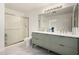 Bathroom featuring a dual sink vanity, modern lighting, and glass shower at 9415 W Eaton Rd, Phoenix, AZ 85037
