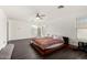 Open bedroom with hardwood floors, modern ceiling fan, and large windows at 9415 W Eaton Rd, Phoenix, AZ 85037