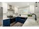 Charming kitchen features white upper cabinets, blue lower cabinets, stainless steel appliances, and tile backsplash at 9415 W Eaton Rd, Phoenix, AZ 85037