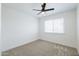 Cozy bedroom with neutral carpet, ceiling fan, and large window for natural light at 948 S Alma School Rd # 1, Mesa, AZ 85210