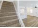 Staircase with carpeted steps leads to an open living space featuring light hardwood floors at 948 S Alma School Rd # 1, Mesa, AZ 85210
