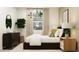 Chic bedroom with a statement light fixture, textured linens, and sleek, dark furniture accents at 9522 W Avalon Dr, Phoenix, AZ 85037