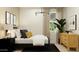 This is a cozy bedroom with a large window, a dresser, and a black and white rug at 9522 W Avalon Dr, Phoenix, AZ 85037