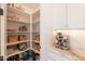 Organized walk-in pantry with shelving, woven baskets, white cabinets, and countertop with appliances at 9645 E Ripple Dr, Mesa, AZ 85212