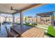 Covered patio with ceiling fan overlooking pool, pergola with outdoor seating and artificial turf at 9645 E Ripple Dr, Mesa, AZ 85212