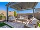 Outdoor seating area under a pergola with ceiling fan and built-in grill at 9645 E Ripple Dr, Mesa, AZ 85212