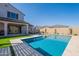 Pool with baja step, stone pavers, artificial turf, with covered patio and lounge chairs at 9645 E Ripple Dr, Mesa, AZ 85212