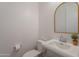 Clean powder room featuring a white pedestal sink, gold-trimmed mirror, and tiled floors at 9645 E Ripple Dr, Mesa, AZ 85212