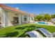 A backyard paradise with a covered patio, pristine pool, and artificial turf at 10155 E Wood Dr, Scottsdale, AZ 85260