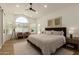 Spacious main bedroom with a large window, neutral decor, and a ceiling fan with great natural light at 10155 E Wood Dr, Scottsdale, AZ 85260