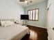 Well-lit bedroom featuring hardwood floors, shuttered window, and TV on a stand at 10572 E Autumn Sage Dr, Scottsdale, AZ 85255