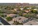 Aerial view of backyard featuring lush landscaping, desert surroundings, outdoor kitchen, and fire pit at 11193 N 121St Way, Scottsdale, AZ 85259
