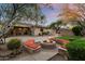Lush backyard featuring a built-in fire pit with custom stone seating for entertaining guests at 11193 N 121St Way, Scottsdale, AZ 85259