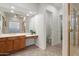 Bright bathroom features a sink with brown cabinets, drawers, and tile flooring at 11193 N 121St Way, Scottsdale, AZ 85259