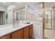 Bathroom sink featuring gold-trimmed shower, glass block, and gold faucets at 11193 N 121St Way, Scottsdale, AZ 85259