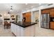Island in the kitchen with stainless refrigerator and transition to the living room at 11193 N 121St Way, Scottsdale, AZ 85259