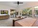 Bright main bedroom featuring a ceiling fan, outdoor access, and large windows with backyard views at 11193 N 121St Way, Scottsdale, AZ 85259