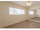 Bedroom with wood-look floors, ceiling fan, large window, and mirrored wall accents at 1124 S Longwood Loop, Mesa, AZ 85208