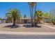 Charming single-story home featuring desert landscaping, a covered porch, and mature palm trees at 1124 S Longwood Loop, Mesa, AZ 85208