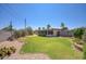 Backyard with green grass, desert plants, rock features and block fence at 12220 N 22Nd Pl, Phoenix, AZ 85022