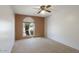 This carpeted bedroom has natural light from a window with an arched brick wall at 12220 N 22Nd Pl, Phoenix, AZ 85022