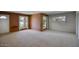 Spacious carpeted living room featuring large windows and brick accents at 12220 N 22Nd Pl, Phoenix, AZ 85022