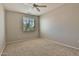 This bedroom features a ceiling fan, window, neutral paint, and carpet flooring at 14870 W Encanto Blvd # 1038, Goodyear, AZ 85395